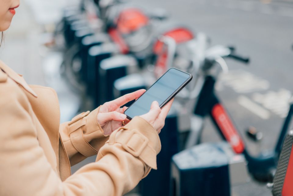 person infront of bikes using an app