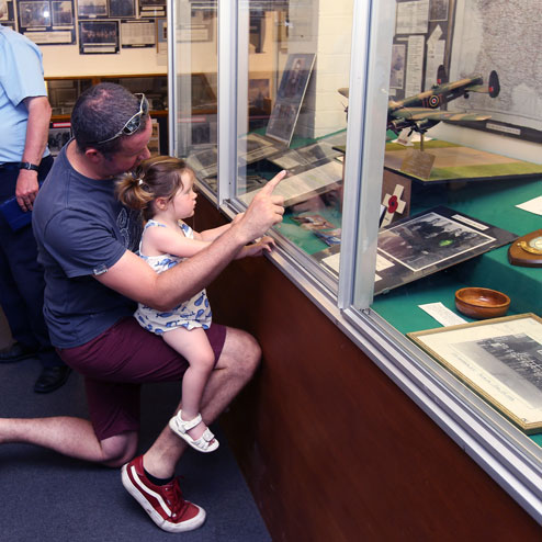Father and daughter looking at exhibits at Waterbeach Military Heritage Museum