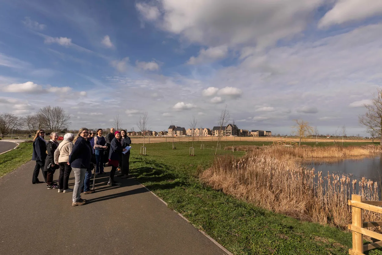 Women walking in a group on a sunny day, engaged in conversation during a wellness walk.