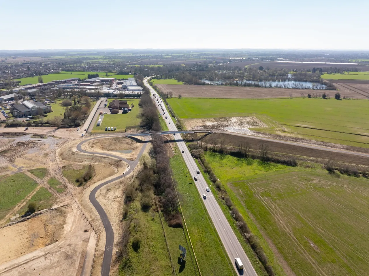 New A10 bridge opens, completing predominantly off-road route between Waterbeach and Cambridge. Image shows an aerial view of the bridge alongside a motorway.